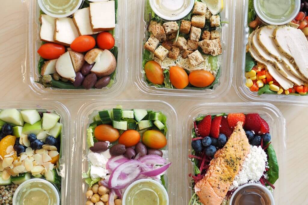 Various to-go containers of salad