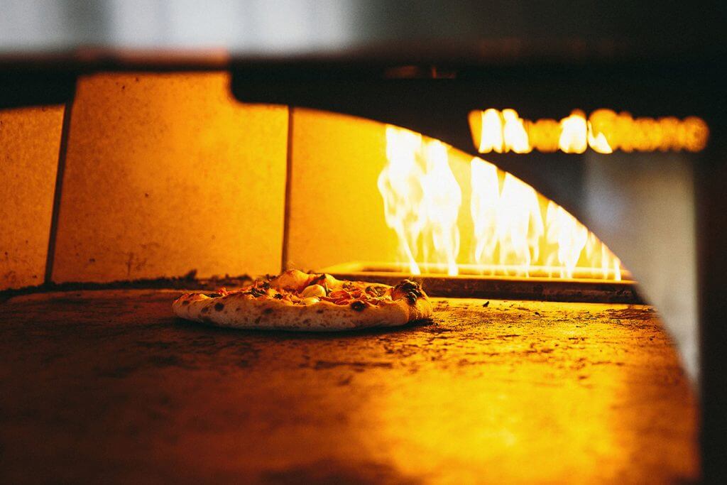 Pizza cooking in a fire grill