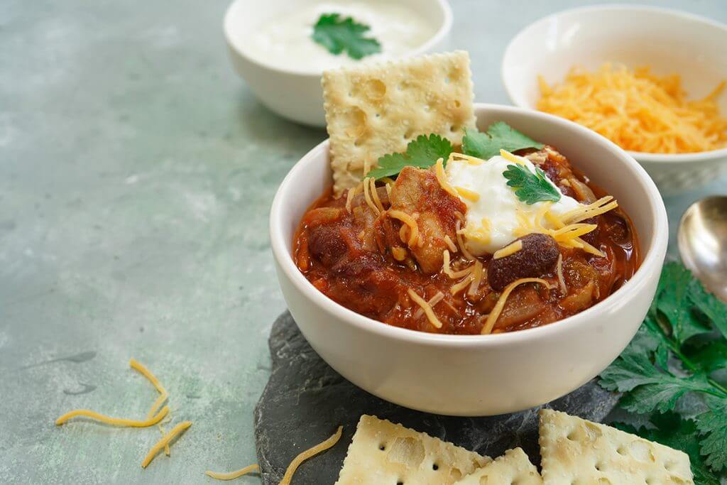Chili served with crackers, cheese, and sour cream