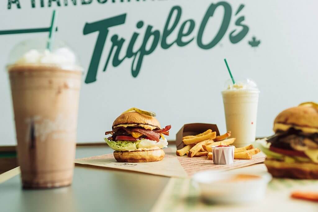 Two burgers, milkshakes, and fries with "Triple O's" in the background