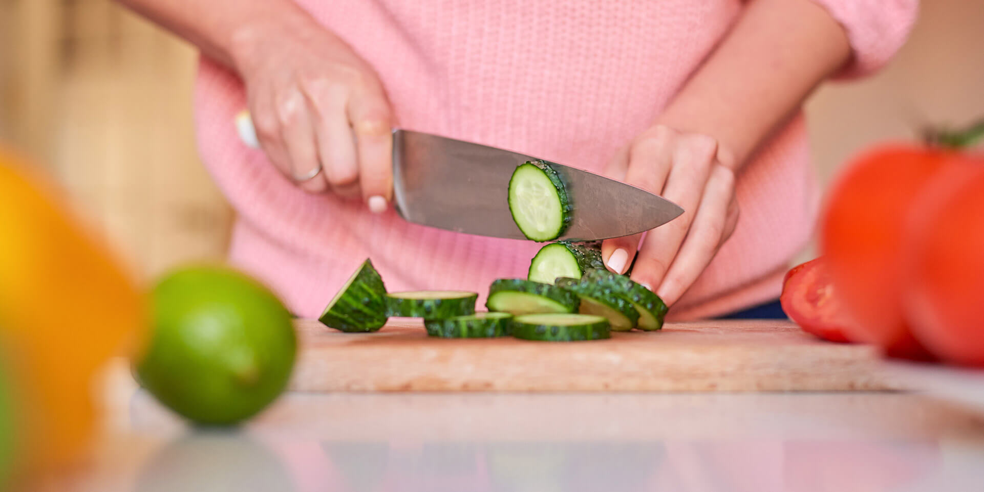 Person slicing a cucumber