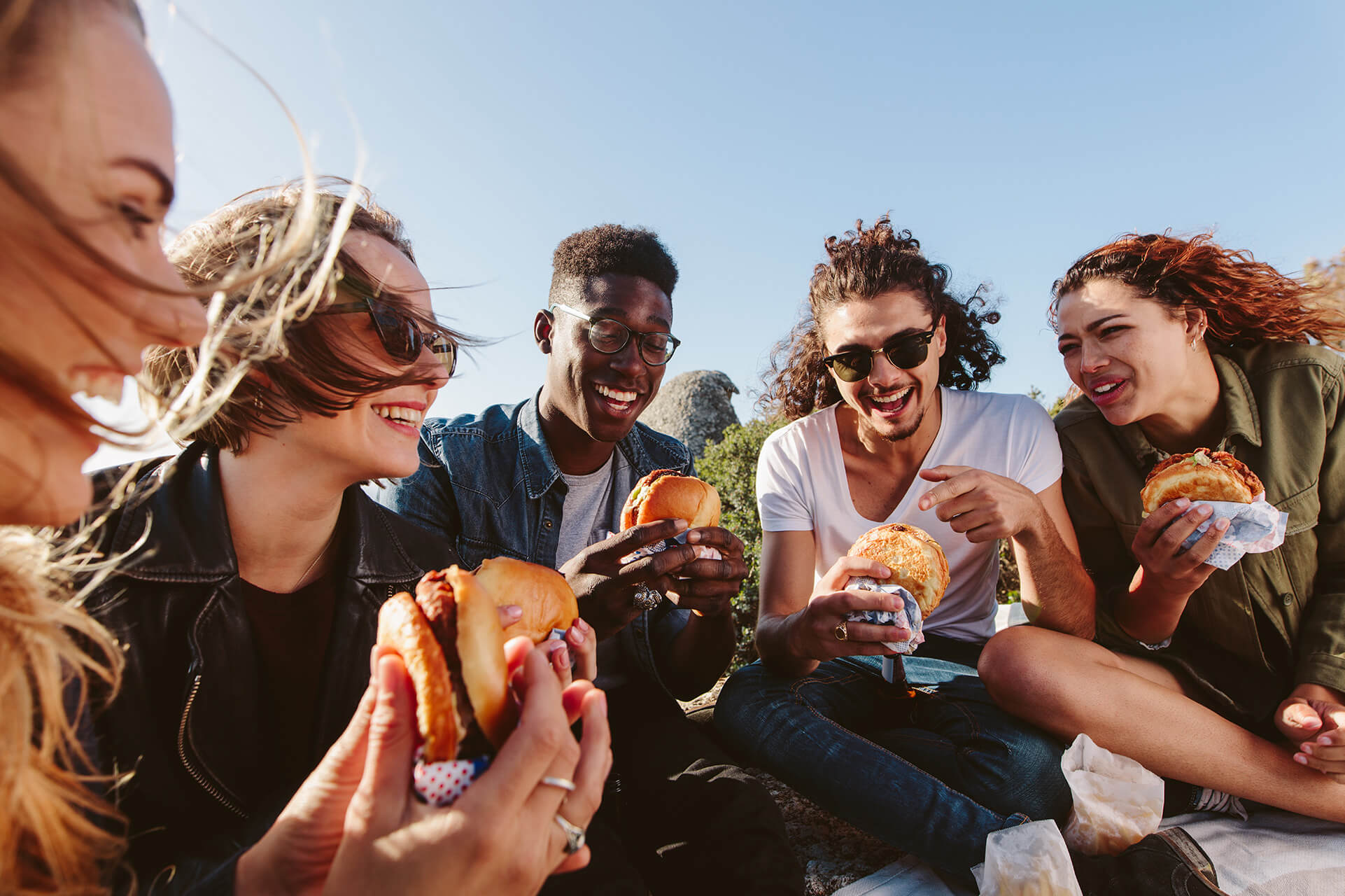 A group of friends enjoying burgers outside