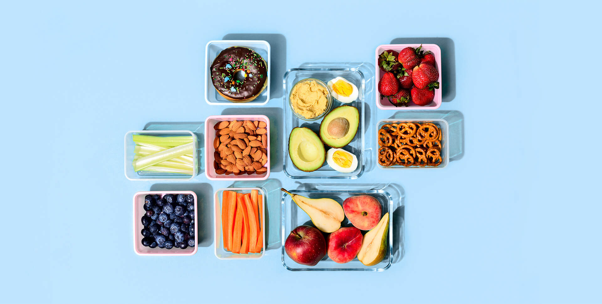 Various types of snacks in reusable containers against a light blue background