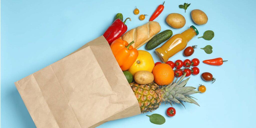 Spilling grocery bag with fruits, vegetables, and grains