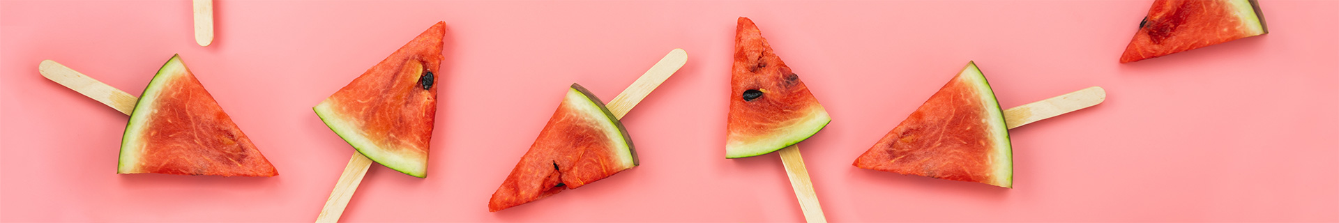 Watermelon on sticks against a pink background