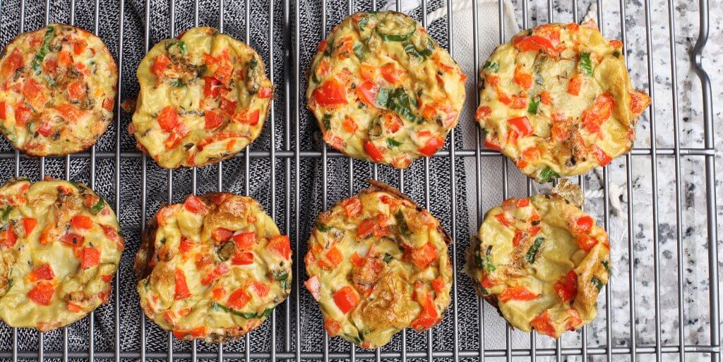 Eight fresh egg muffins cooling on metal tray