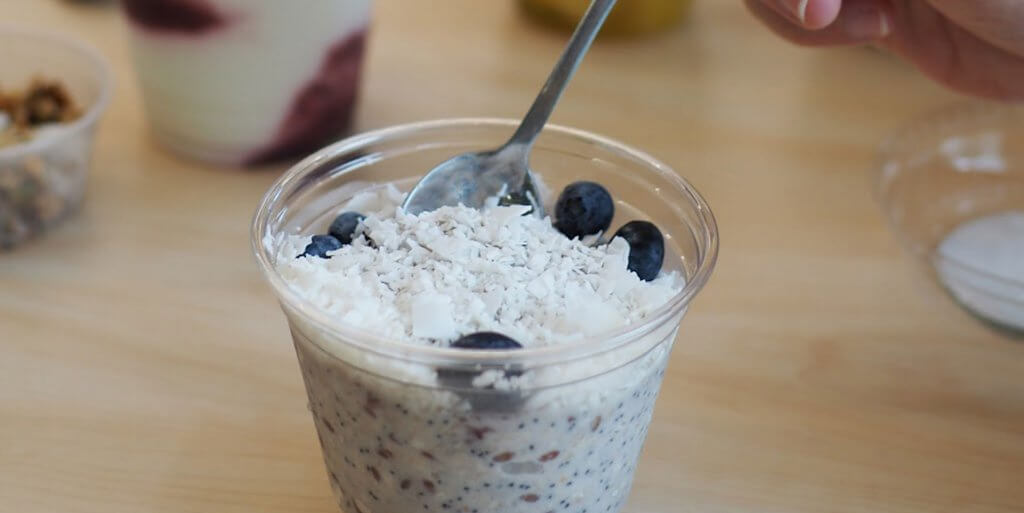 Spoon dipping into a cup of blueberry overnight oats