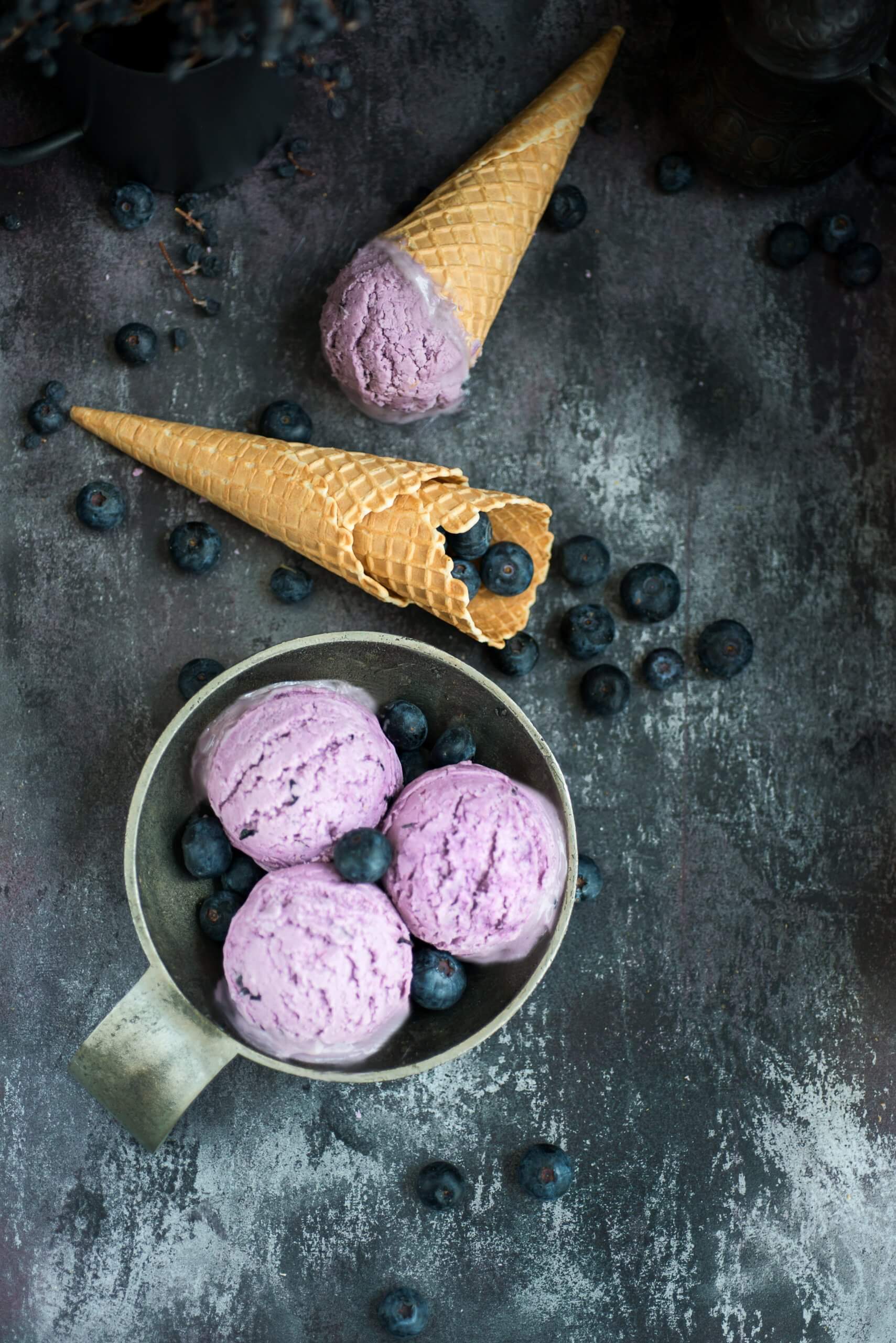blueberry ice cream in a mug and tiny sugar cones with fresh blueberries