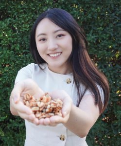 Gloria Sun, Registered Dietitian, holding out a handful of nuts.