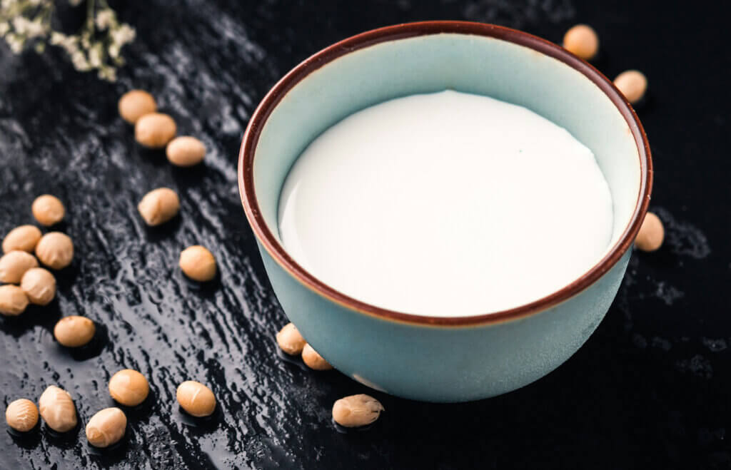 Image Description: Milk in a blue bowl with legumes scattered on a table